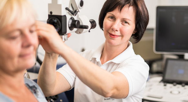 Dr. med. Claudia Ernstberger untersucht das Ohr einer Patientin